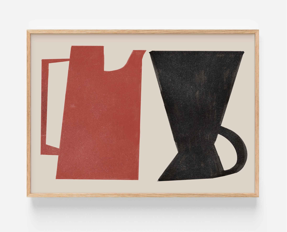A framed abstract art print featuring a red pitcher and a black coffee dripper on a cream background, enclosed in a light wood frame.
